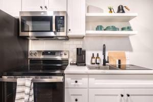 una cocina con estufa y microondas en Elegant Downtown Escape with Luxe Vibes, en Macon