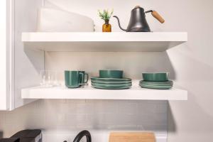 Un estante con platos verdes en la cocina en Elegant Downtown Escape with Luxe Vibes, en Macon