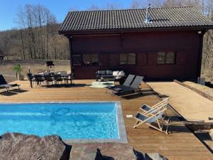 斯塔沃洛Chalet cosy Francorchamps的一座带庭院的房屋前的游泳池