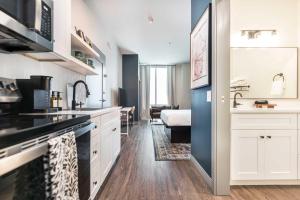 a kitchen with white cabinets and a living room at Chill Like Gregg Sunlit Southern Vibe in Macon