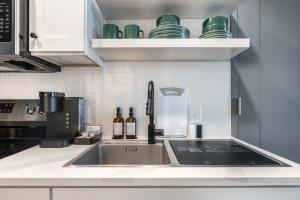 a kitchen with a sink and some bottles and cups at Chill Like Gregg Sunlit Southern Vibe in Macon