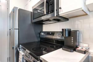 a kitchen with a stove and a stainless steel refrigerator at Chill Like Gregg Sunlit Southern Vibe in Macon +9 photos