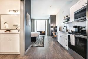 Una cocina con gabinetes blancos y una cama en una habitación. en Widespread Panic Vibes and Comfort Stay, en Macon