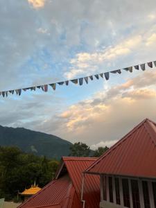 a string of flags flying over a red roof at Rang Khem - Our Home in Tawang