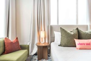 Un dormitorio con una cama, un sofá y una silla. en Turn Back Time Cher-Inspired Escape, en Macon