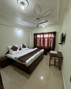 a bedroom with a large bed and a window at Hotel Naya Kashmir in Srinagar