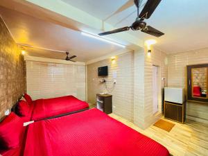 a bedroom with a red bed and a tv at Grand view lodge and Restaurant Dharamshala - Partial Prepayment required to confirm booking in Dharamshala