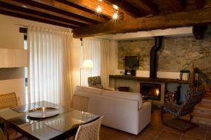 a living room with a couch and a table and a fireplace at Apartamentos Rurales El Lleron in Caso