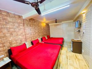 a red couch in a room with a brick wall at Grand view lodge and Restaurant Dharamshala - Partial Prepayment required to confirm booking in Dharamshala