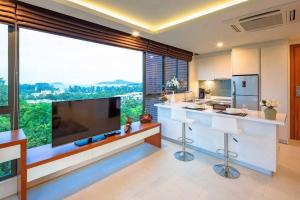 una cucina con una grande televisione e una grande finestra di At the tree by fatimah R315 a Rawai Beach Altre 29 foto