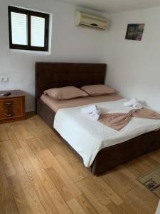 a bedroom with a bed and a wooden floor at Guesthouse N&B in Berat