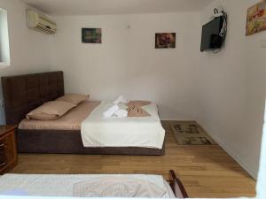 a small bedroom with a bed and a television at Guesthouse N&B in Berat