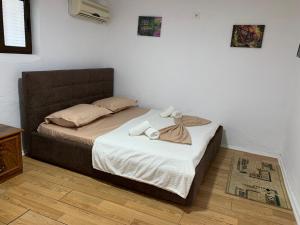 a bedroom with a large bed with a brown headboard at Guesthouse N&B in Berat +16 photos