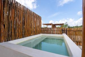 a swimming pool in front of a wooden fence at Moonstone - Villa with private pool and 24hrs security & Beach club access in Tulum