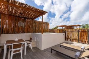 a patio with a table and chairs and a wooden fence at Moonstone - Villa with private pool and 24hrs security & Beach club access in Tulum