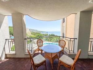 a balcony with a table and chairs and a view of the ocean at Queen's Lounge in Balchik