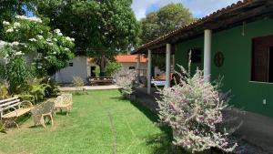 a yard with a green house with a bench at Village por do sol in Aracaju