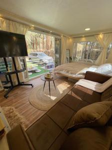 a bedroom with a bed and a couch and a table at كرفان العلا caravan alula in Al-ʿUla