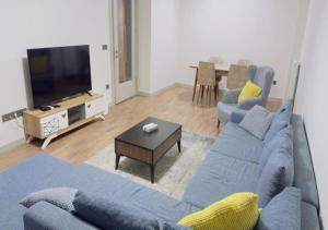 Una sala de estar con un sofá azul y un televisor. en Dimer country, en Beylikduzu