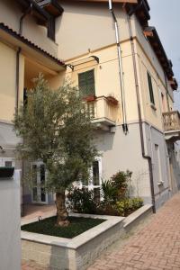 a tree sits in front of a building at Appartamenti Leonardo in Rho