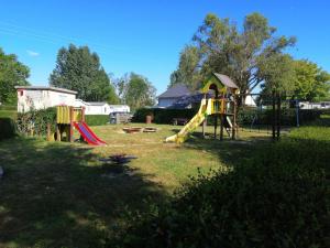 Un parque infantil con un tobogán en un patio en Mobil-home, en Saint-Pair-sur-Mer