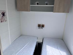 Una pequeña habitación con dos camas. en Mobil-home, en Saint-Pair-sur-Mer 5 fotos más