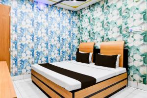 a bedroom with a bed with a blue and white wallpaper at HOTEL O Aanandalok in kolkata