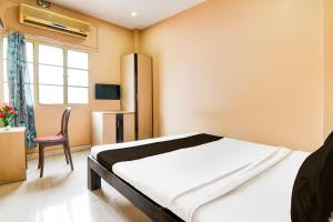 a bedroom with a bed and a chair in it at HOTEL O Aanandalok in kolkata