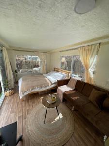 a bedroom with a bed and a couch and a table at كرفان العلا caravan alula in Al-ʿUla