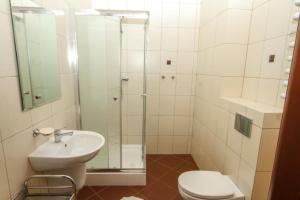 un bagno con doccia, lavandino e WC di Wielorybek Junior a Kąty Rybackie