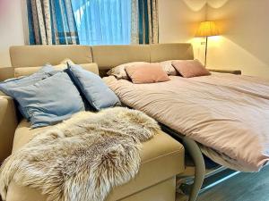 a bed with a furry blanket and pillows on it at Alpenblick Apartment in Hermagor