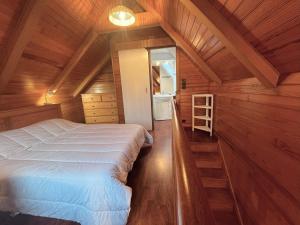 a bedroom with a white bed in a wooden room at Maison bretonne 2 personnes centre ville St Pol de Léon in Saint-Pol-de-Léon