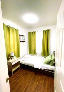 a bedroom with a bed and a window with green curtains at Adorable Panglao Vacation House in Dauis +18 photos