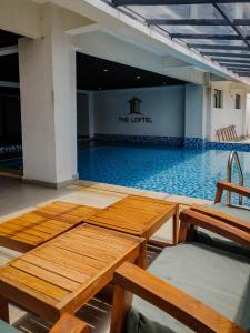 ein Swimmingpool mit einem Tisch und Stühlen davor in der Unterkunft GRE homes Studio apartment in Ruaka