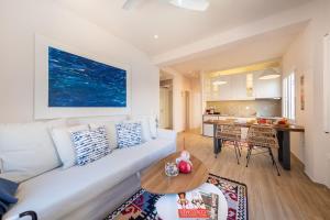 un salon avec un canapé blanc et une table dans l'établissement Finestra Sul Mare Corfu - Sea & Sun Stay, à Corfu