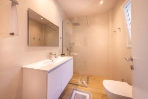 une salle de bain blanche avec un lavabo et des toilettes dans l'établissement Finestra Sul Mare Corfu - Sea & Sun Stay, à Corfu 17 autres photos