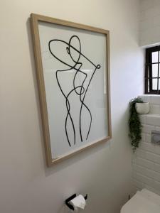 a picture of a woman in a dress on a bathroom wall at Tides End in Ballito