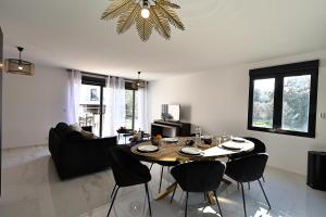 a living room with a table and some chairs at Maelle - T4 Moderne à Bonifacio in Bonifacio