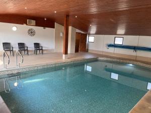 a large swimming pool with chairs and a table at Oak Apple in Plaitford