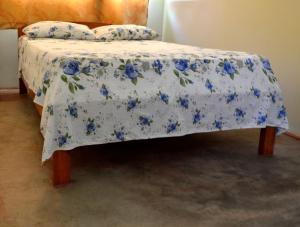 Una cama con una manta azul y blanca. en Indiana Lodge, en Mazán