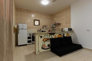 a kitchen with a refrigerator and a table with a chair at Wanas hostel in Dahab