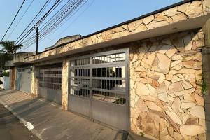 un edificio con dos puertas de garaje y una pared de piedra en 0005 - Pousada HG quarto home office single, en Guarulhos 7 fotos más