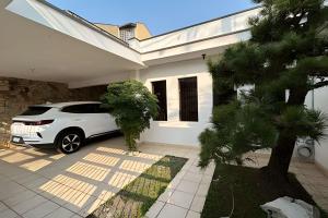 Un coche blanco aparcado delante de una casa en 0005 - Pousada HG quarto home office single, en Guarulhos