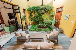 a living room with couches chairs and a table at Casa La Escondida in Mérida