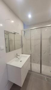 un bagno bianco con lavandino e doccia di Sunhouse a Luz Altre 12 foto