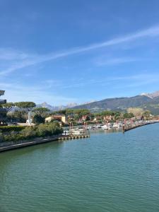a river with a town and mountains in the background at Relax between the sea and the mountains in Cinquale