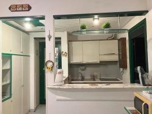 a kitchen with white cabinets and potted plants on the counter at Relax between the sea and the mountains in Cinquale