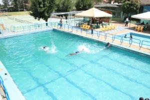 two people swimming in a large swimming pool at Sadili Oval B & B in Nairobi
