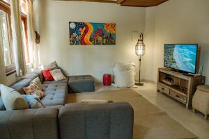 a living room with a couch and a flat screen tv at Espaço CurAmar - Praia de Itamambuca in Ubatuba