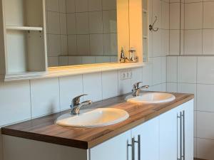 a bathroom with two sinks and a mirror at Juli-Huus in Bastorf